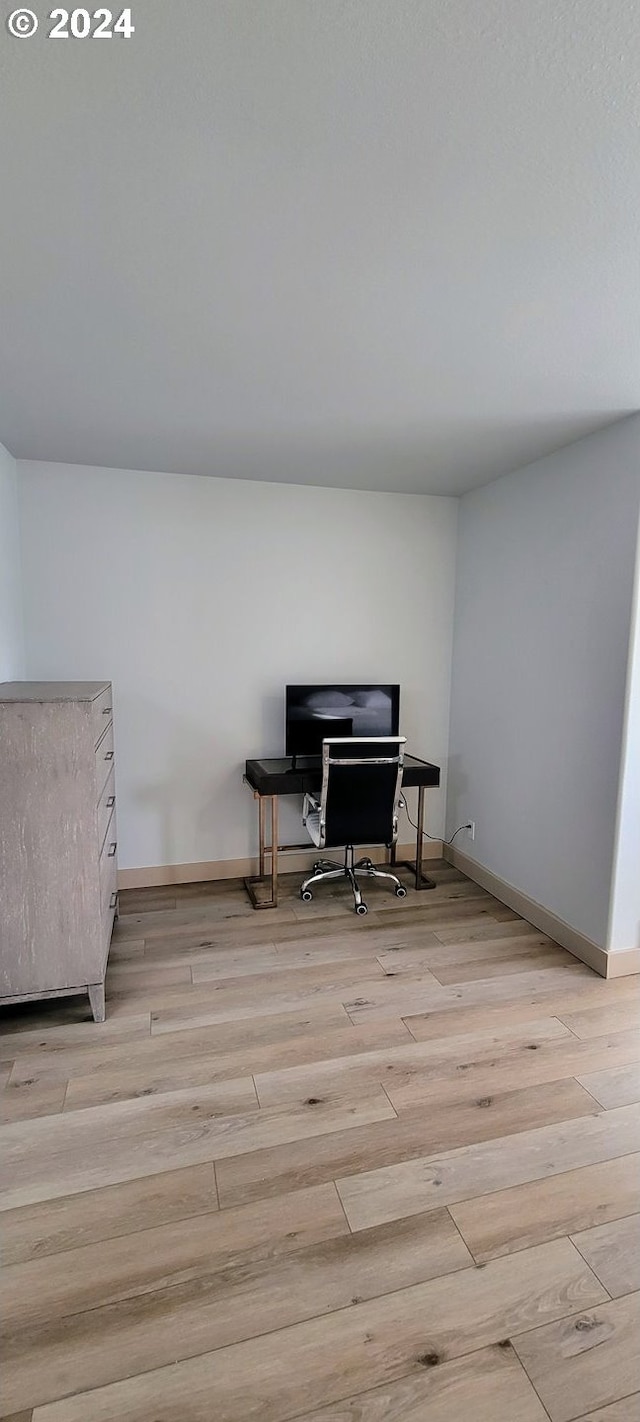 sitting room with baseboards and wood finished floors