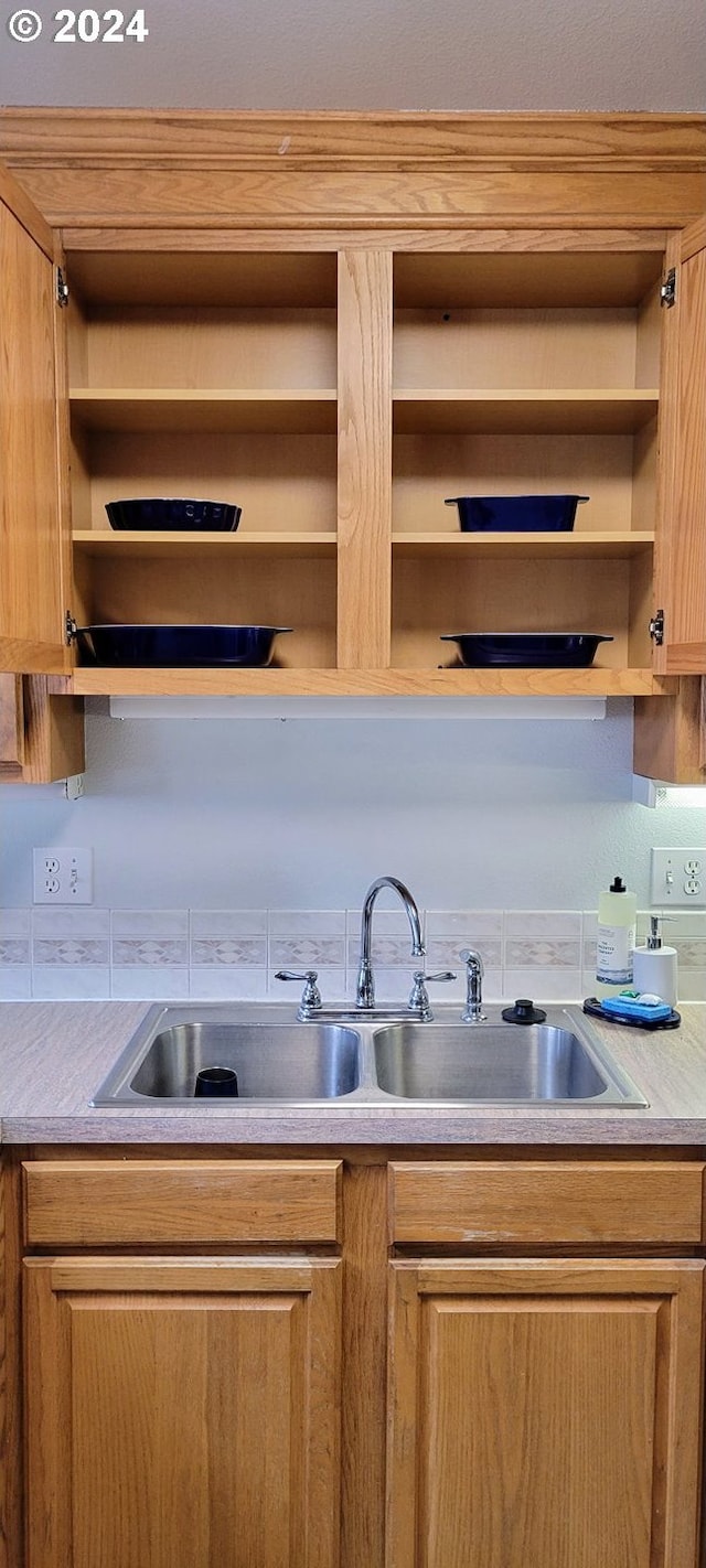 kitchen with open shelves, a sink, and light countertops