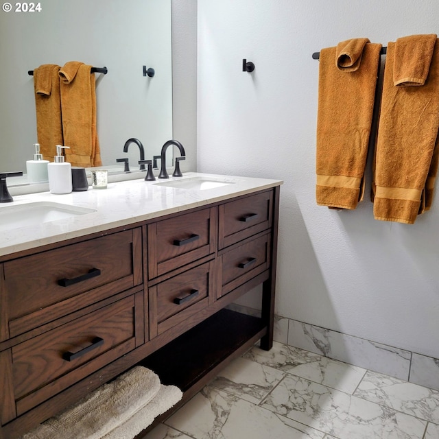 bathroom featuring double vanity, a sink, and marble finish floor