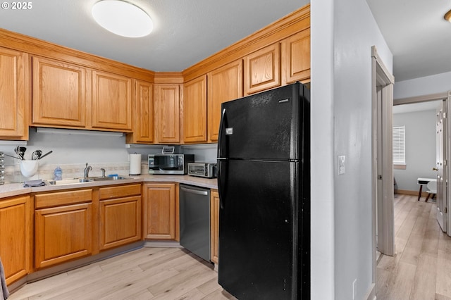 3979 NE Johns Ave, Neotsu, OR 97364 - kitchen with stainless steel appliances, a sink, light wood finished floors, and light countertops