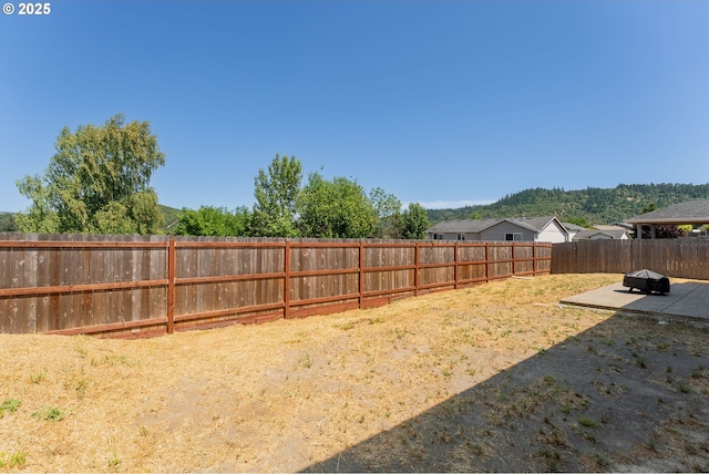 360 NE Rose Ridge Dr, Winston, OR 97496 - fenced backyard featuring a patio area and an outdoor fire pit