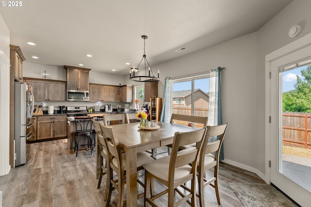 360 NE Rose Ridge Dr, Winston, OR 97496 - dining room featuring healthy amount of natural light, light wood-style floors, recessed lighting, and a chandelier