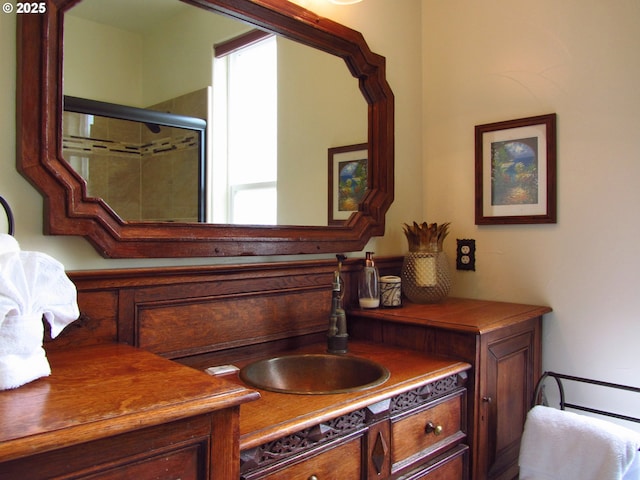 bathroom featuring walk in shower and vanity