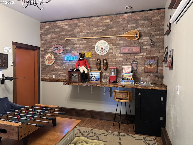 bar with brick wall, wood-type flooring, and sink