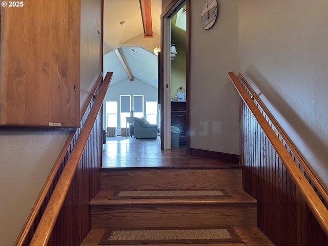 staircase featuring vaulted ceiling with beams and hardwood / wood-style flooring