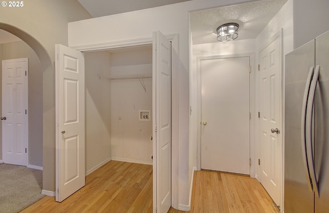 hallway featuring a textured ceiling and light wood-type flooring