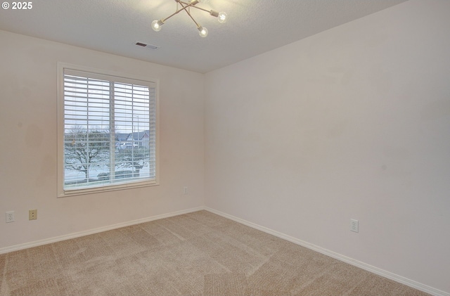 carpeted spare room with a textured ceiling