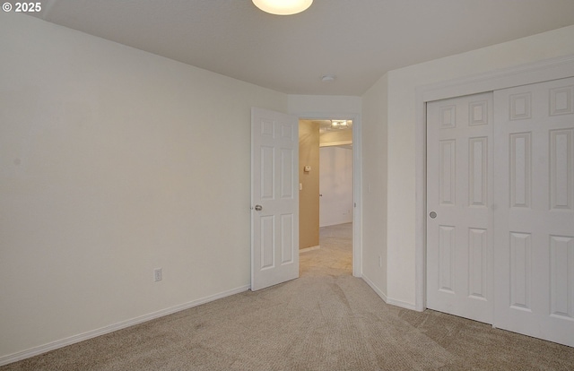 unfurnished bedroom featuring a closet and light carpet