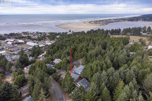 birds eye view of property with a water view and a beach view