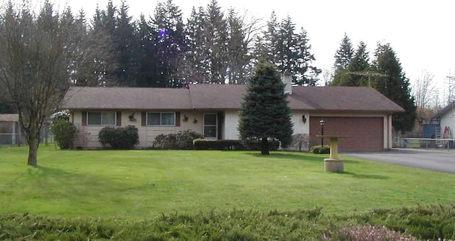 ranch-style home with driveway, a garage, and a front yard