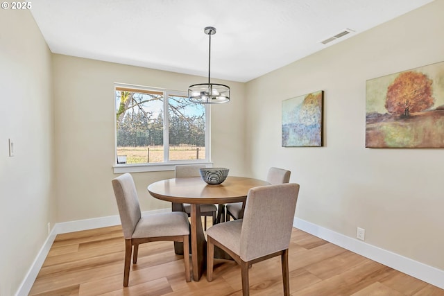 dining space with an inviting chandelier and light wood-type flooring