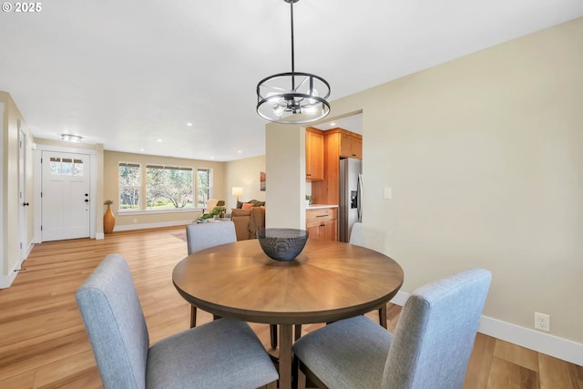 dining space featuring a notable chandelier and light hardwood / wood-style floors