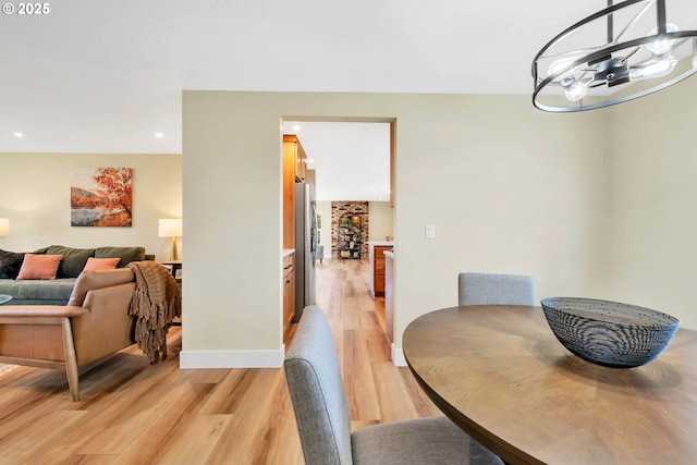 dining room with a notable chandelier and light wood-type flooring