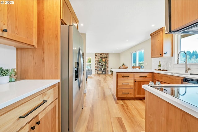 kitchen featuring appliances with stainless steel finishes, sink, decorative backsplash, and light wood-type flooring