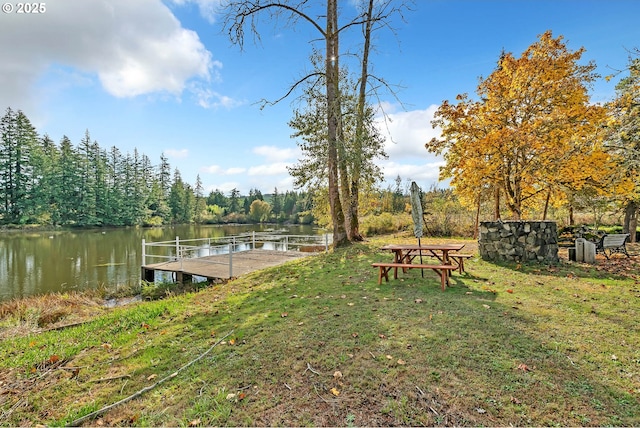 view of dock with a water view and a yard