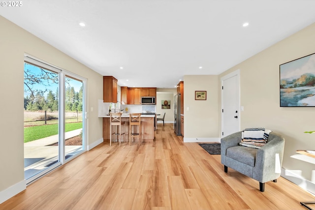 living room featuring sink and light hardwood / wood-style flooring