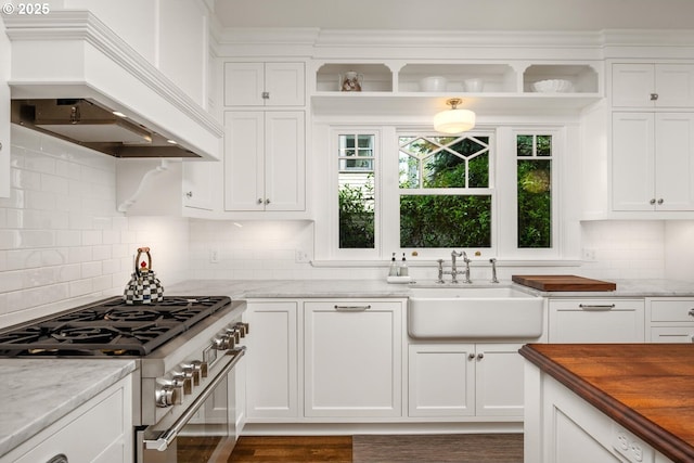2424 NW Northrup St, Portland, OR 97210 - kitchen with premium range hood, high end stainless steel range, white cabinetry, and a sink
