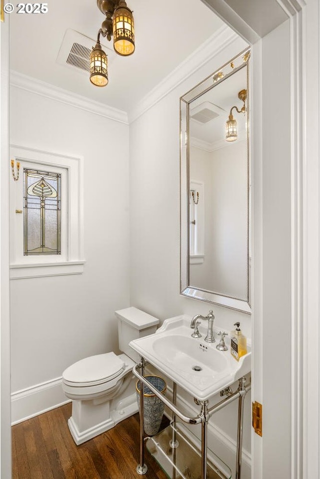2424 NW Northrup St, Portland, OR 97210 - half bathroom featuring crown molding, wood finished floors, toilet, a sink, and baseboards