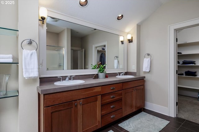 full bath featuring tile patterned floors, double vanity, a sink, and a spacious closet