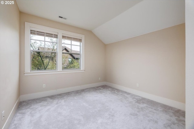 additional living space with baseboards, lofted ceiling, carpet, and visible vents