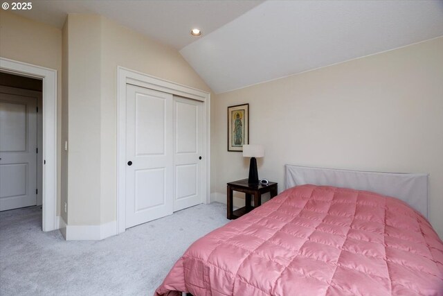 carpeted bedroom with a closet, recessed lighting, baseboards, and vaulted ceiling