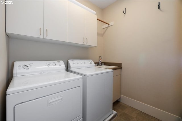 laundry room with separate washer and dryer, a sink, baseboards, and cabinet space