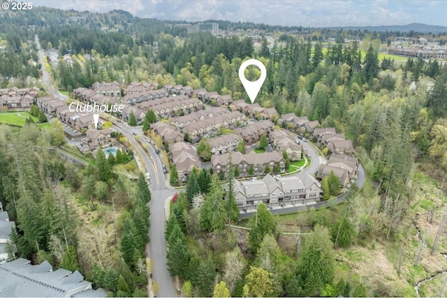 drone / aerial view featuring a wooded view and a residential view