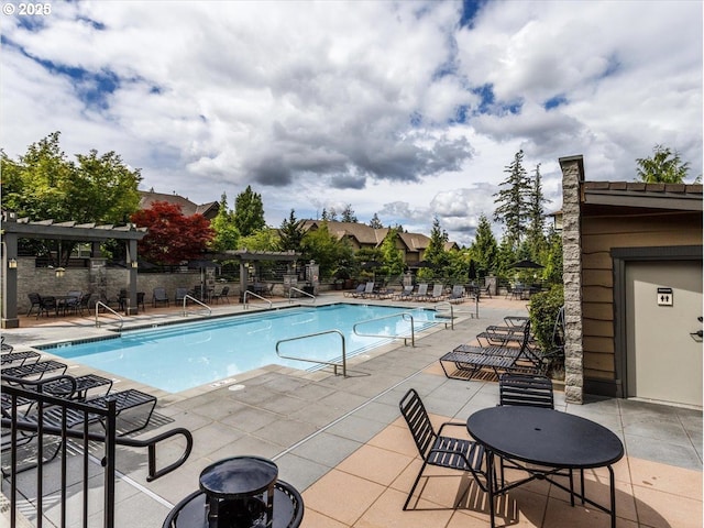 pool with a patio area, fence, and a pergola