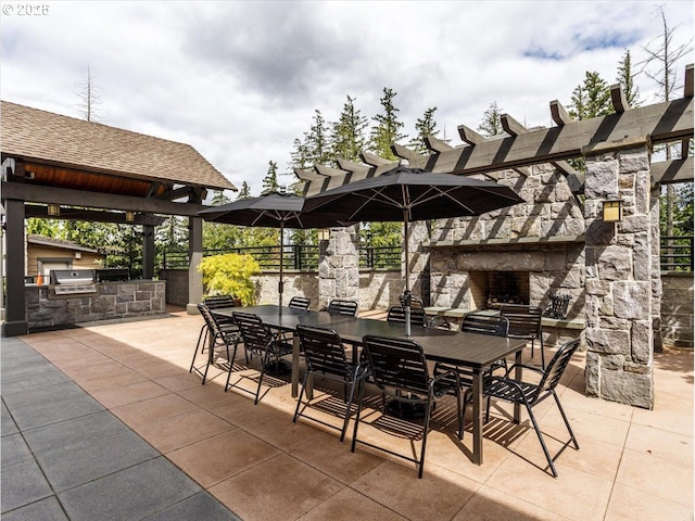 view of patio / terrace featuring exterior kitchen, an outdoor stone fireplace, a pergola, area for grilling, and outdoor dining area