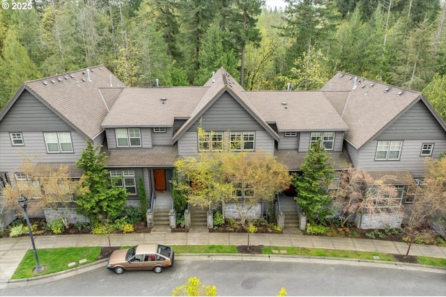 view of front of property with a wooded view