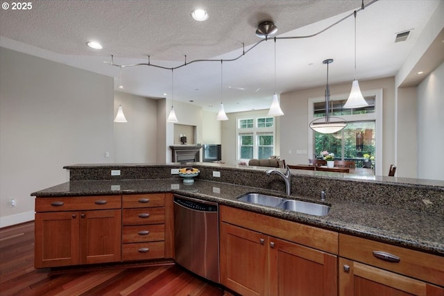 kitchen featuring dark wood-style flooring, visible vents, brown cabinetry, dishwasher, and a sink