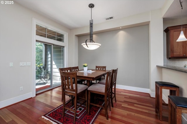 dining room with visible vents, baseboards, and wood finished floors