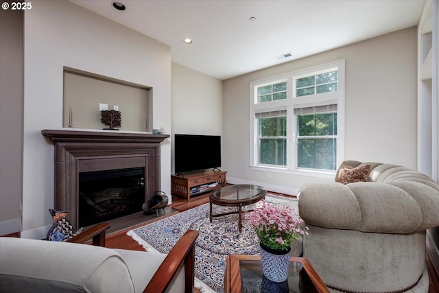 living room with a fireplace, visible vents, recessed lighting, wood finished floors, and baseboards