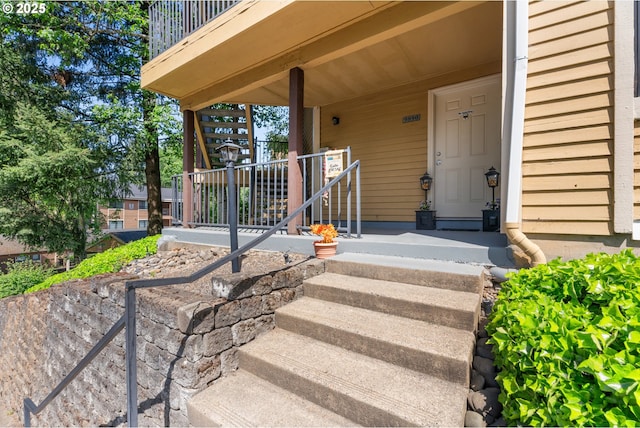 doorway to property with a porch and a balcony