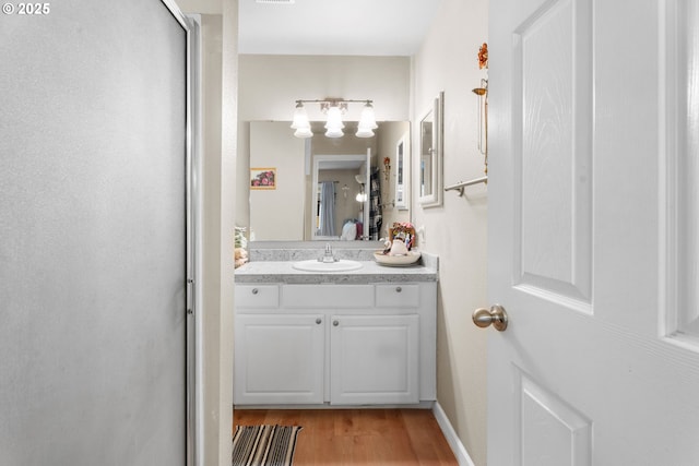 bathroom with vanity, wood finished floors, and a chandelier