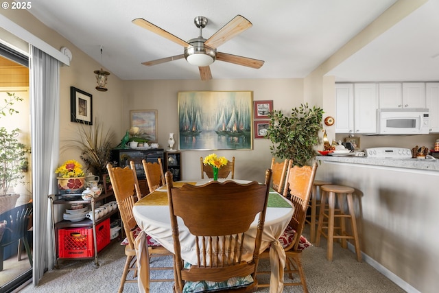 dining area featuring light colored carpet and ceiling fan