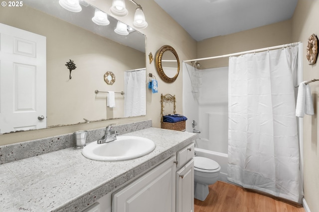 full bathroom with toilet, wood finished floors, vanity, and shower / bath combo with shower curtain