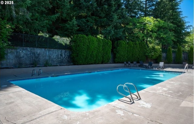 view of swimming pool with a patio area and fence