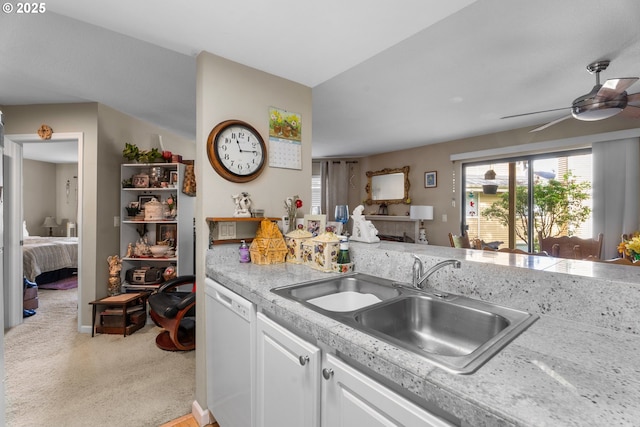 kitchen featuring dishwasher, a sink, plenty of natural light, and light carpet