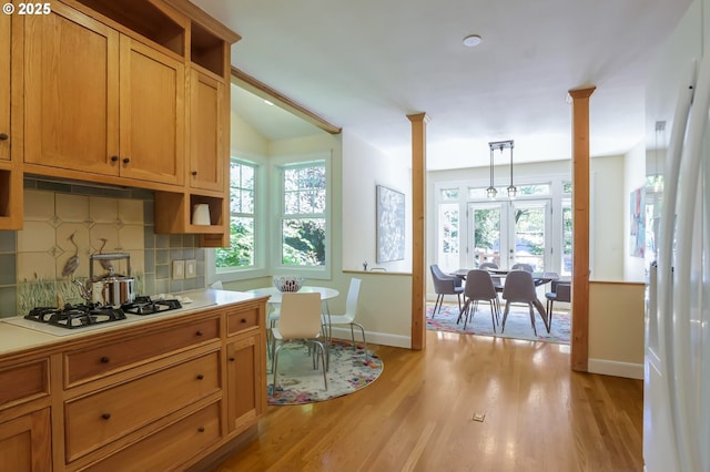 kitchen with white gas stovetop, baseboards, french doors, tasteful backsplash, and light wood-style floors