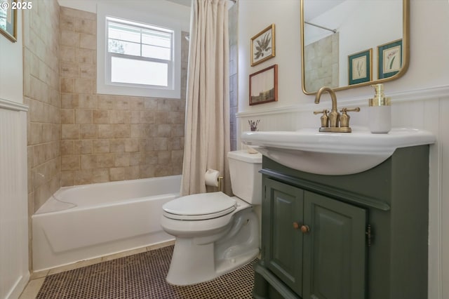 full bath with toilet, shower / bath combo with shower curtain, vanity, a wainscoted wall, and tile patterned flooring