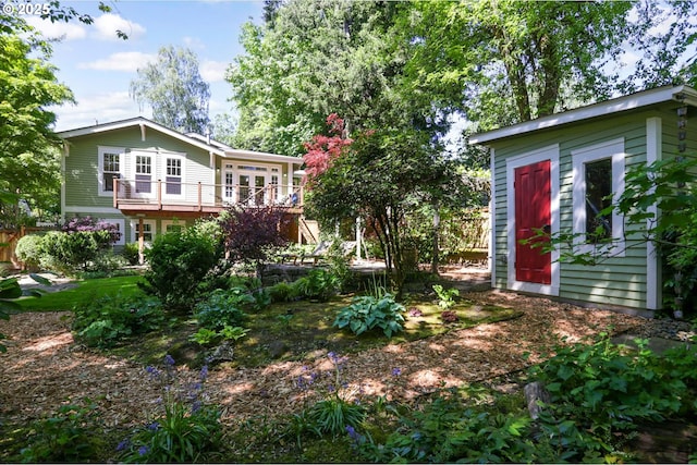 back of property featuring an outdoor structure and a deck