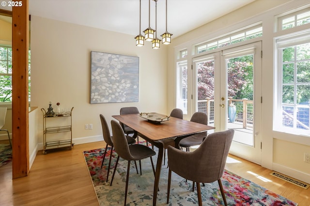 dining space featuring plenty of natural light, light wood-type flooring, and baseboards