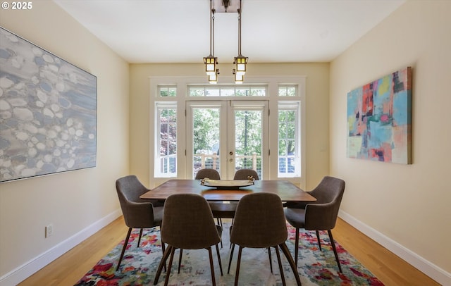 dining room featuring plenty of natural light, light wood-style floors, and baseboards