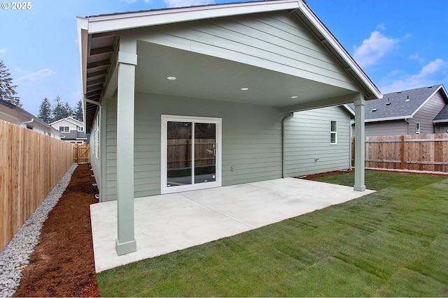 back of house featuring a lawn and a patio area