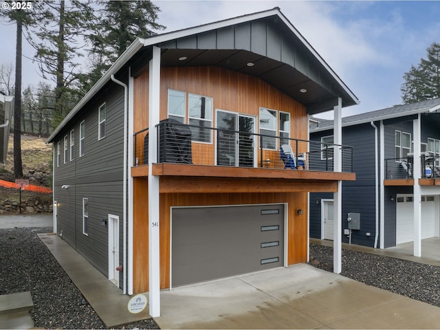 contemporary house with a garage, driveway, and a balcony