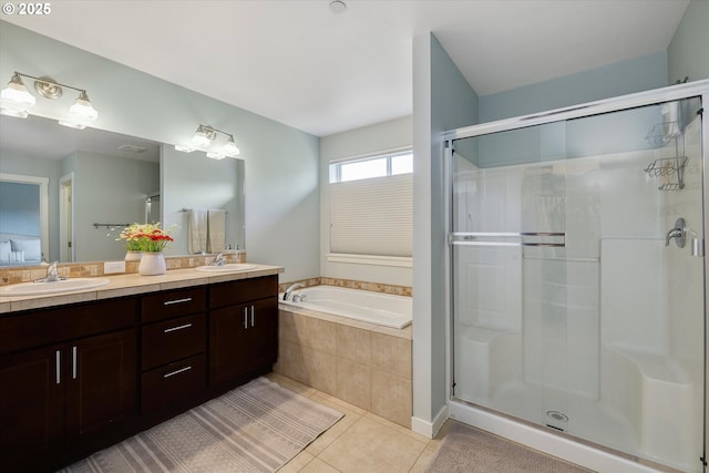 bathroom featuring a garden tub, tile patterned flooring, a stall shower, and double vanity