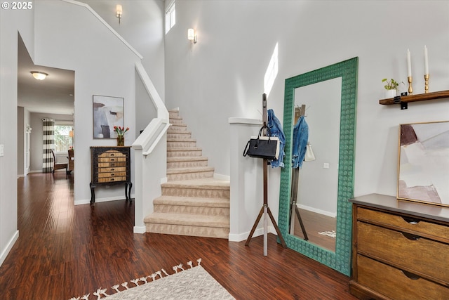 foyer entrance with stairway, wood finished floors, and baseboards