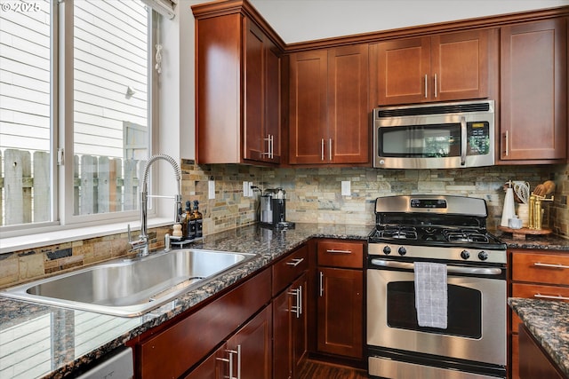 kitchen with stainless steel appliances, a sink, plenty of natural light, and decorative backsplash
