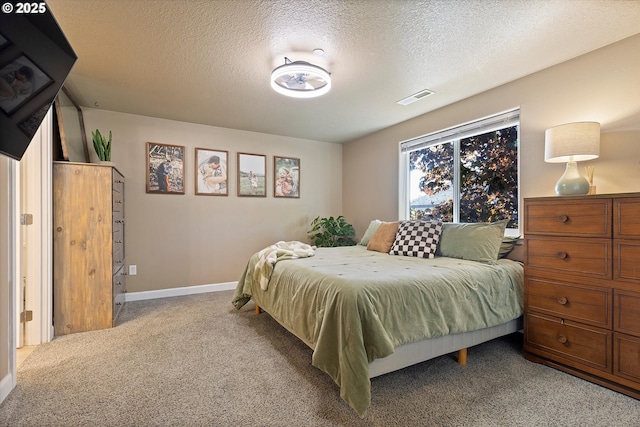 bedroom with visible vents, carpet flooring, a textured ceiling, and baseboards